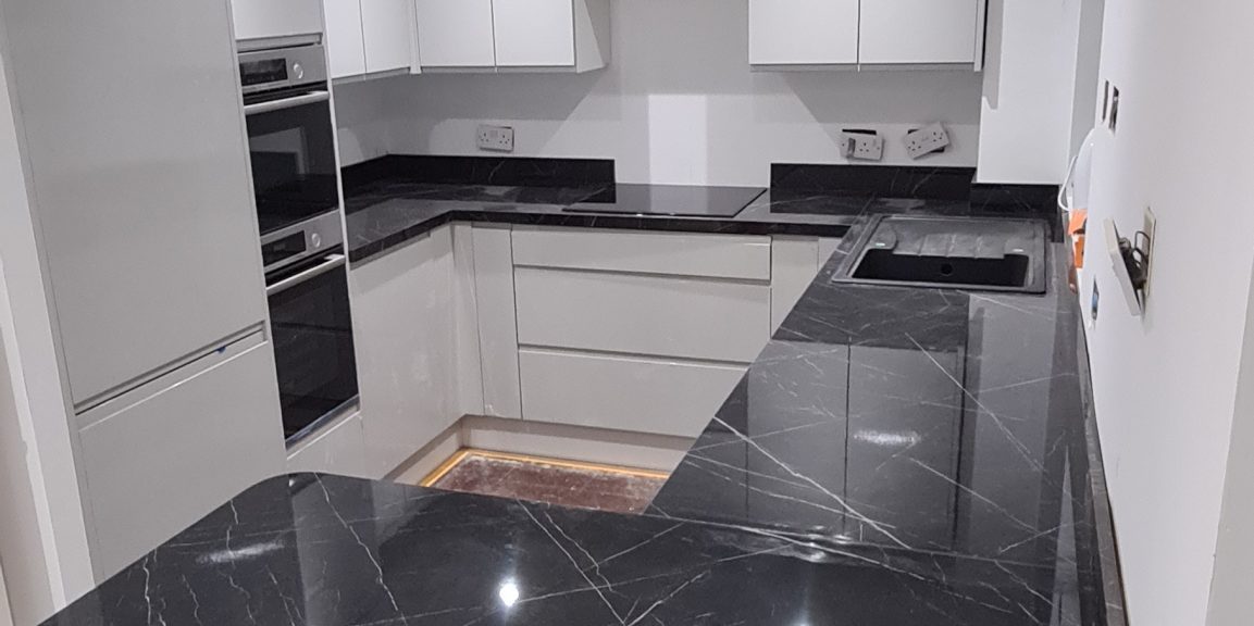 Modern kitchen with white cabinets and black marble countertops